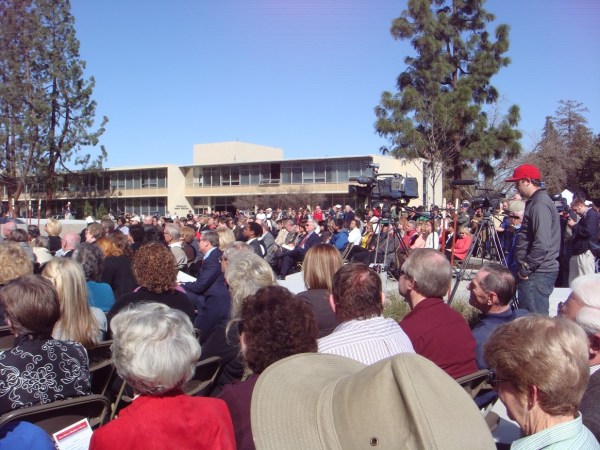 A crowd gathers for the grand reopening of the Library while TV cameras capture the event.