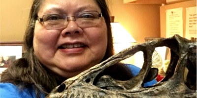 Moore with a Deinonychus (dinosaur) skull demonstrating cataloging