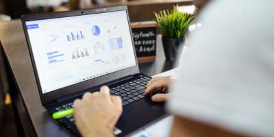 Looking over the shoulder of a student examining data on a laptop