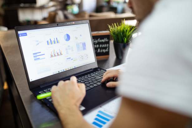 Looking over the shoulder of a student examining data on a laptop