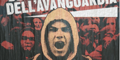 Tamburo dell'avanguardia This poster celebrates Italy's far-right youth as the "Drum[beat] of the Avant-Garde." Produced by Student Bloc, CasaPound Italy's neo-fascist youth group, it depicts an Italian youth shouting while holding a banner along with an anonymous crowd of Student Bloc members in the background. Rendered in a flame-like color palette, the poster evokes youth as a revolutionary force against the socio-political status quo. Source: Photograph by Brian J Griffith (December 28, 2020).