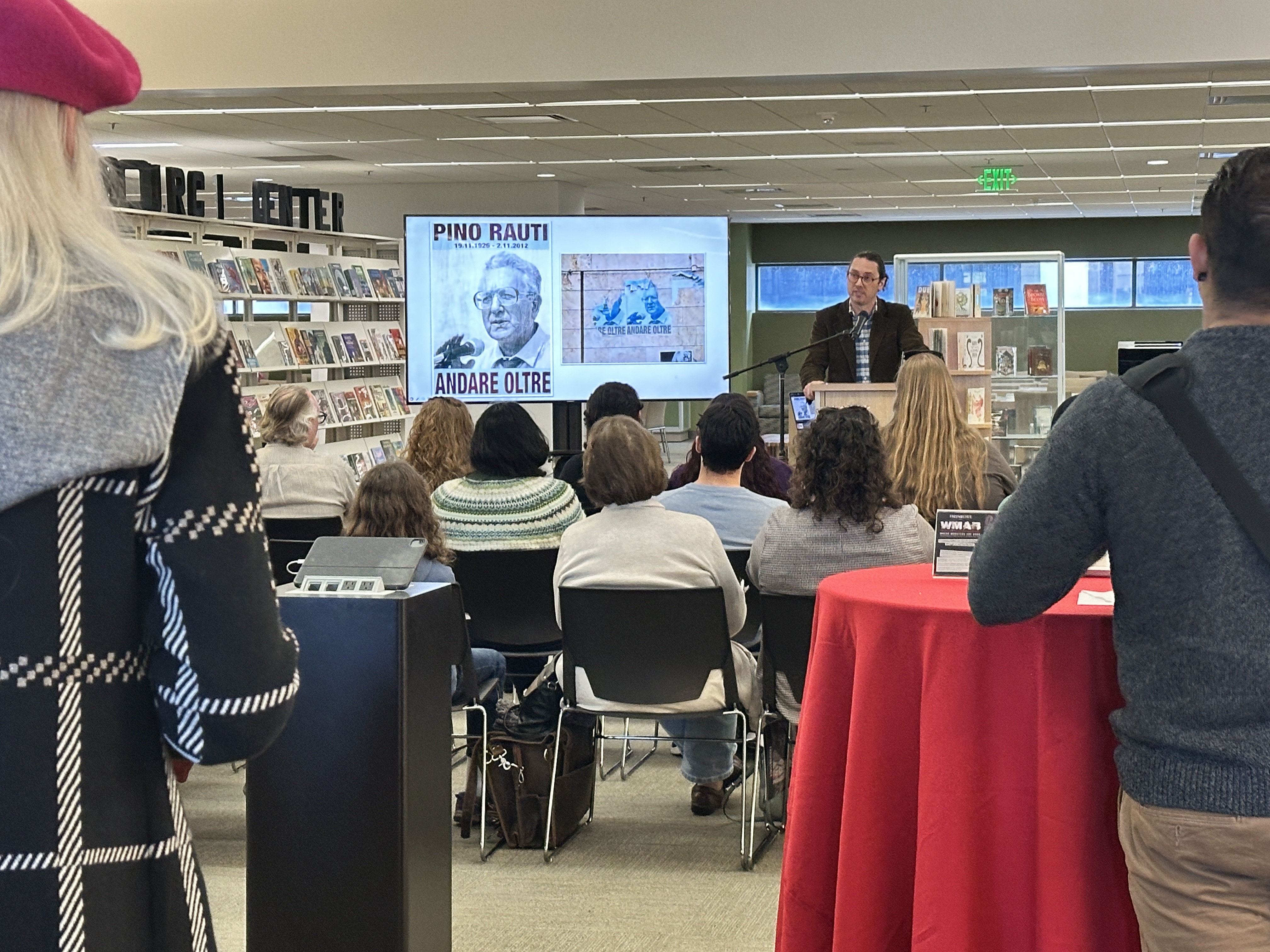 Dr. Griffith speaking at the podium with multimedia playing behind