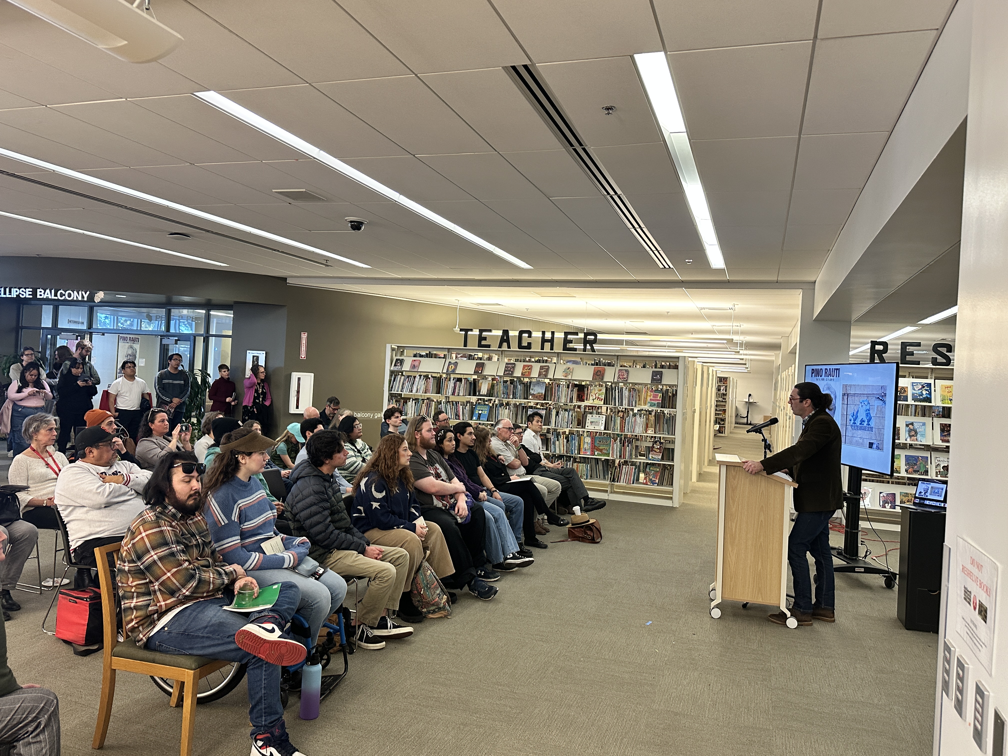 Dr. Griffith speaking at the podium with multimedia playing behind