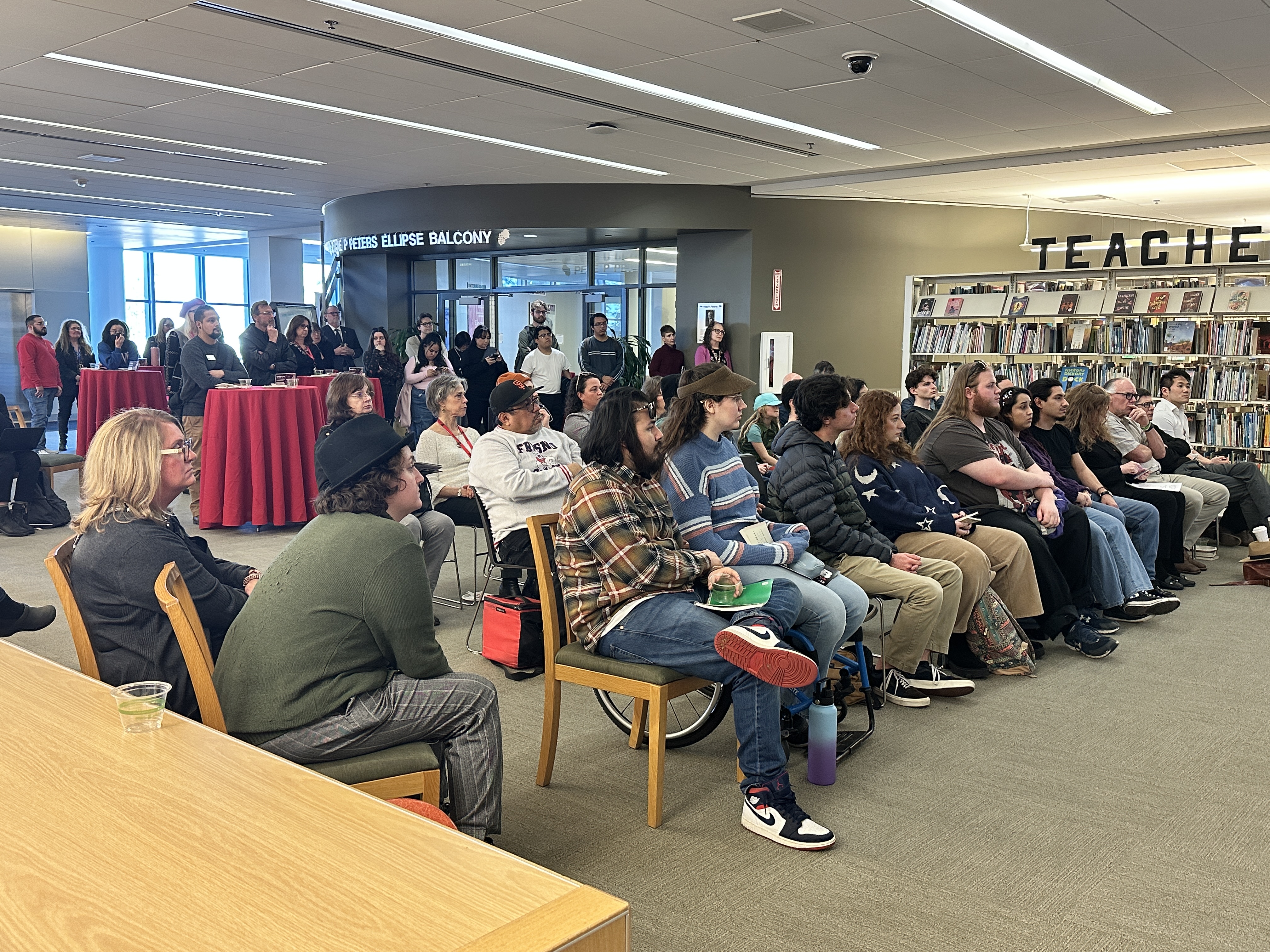 Large crowd seated and standing room only in the back