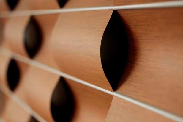detail of the "wavy wall" installation in the library - wavy wood panels braid in and out of each other.