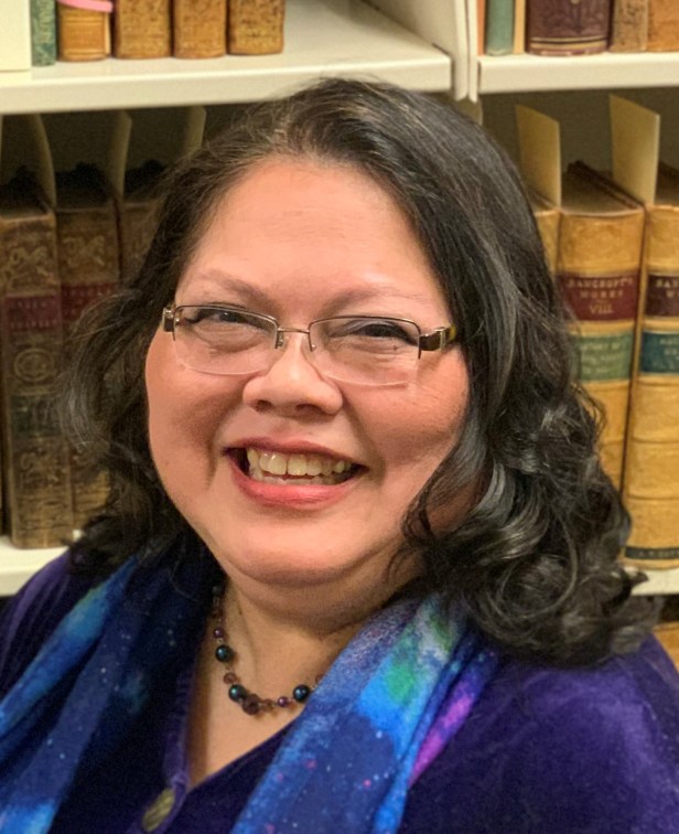Julie Renee Moor in front of books in special collections