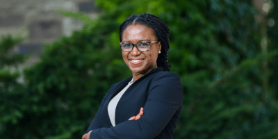 Ifeoma Ajunwa stands smiling in a natural setting