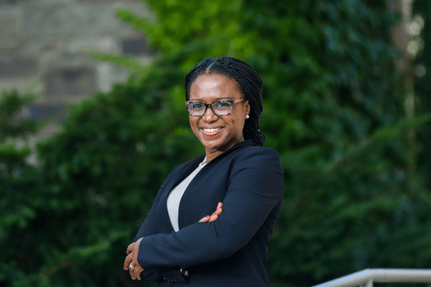 Ifeoma Ajunwa stands smiling in a natural setting